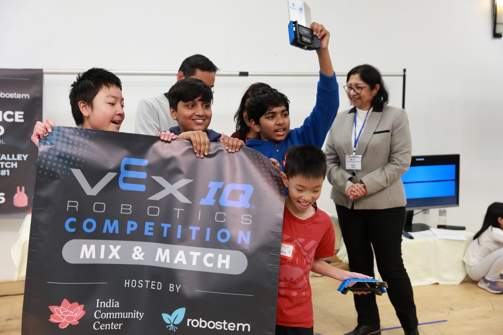 A team holds up the Mix & Match banner and their trophy at the awards ceremony
